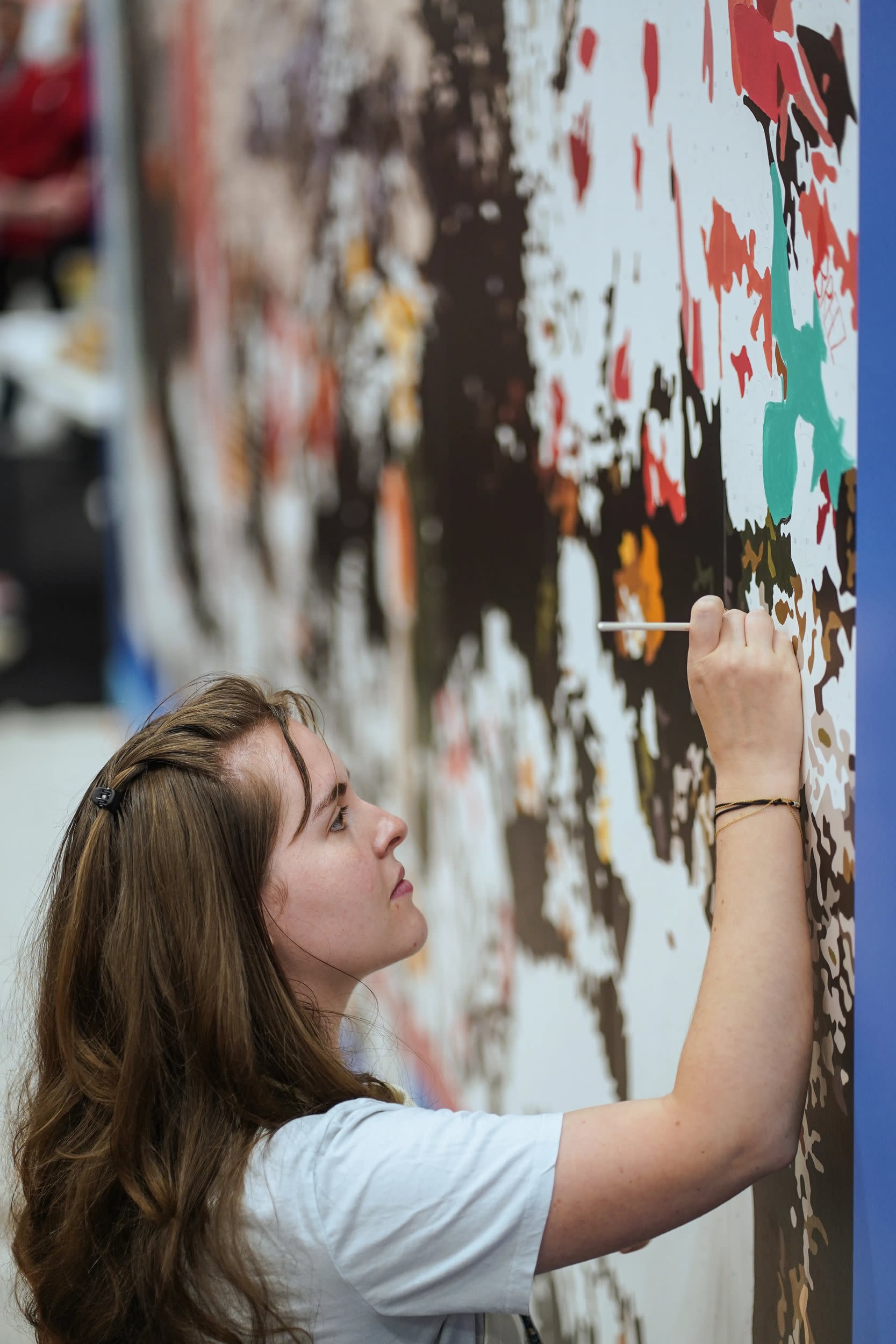 Person painting a mural on a wall