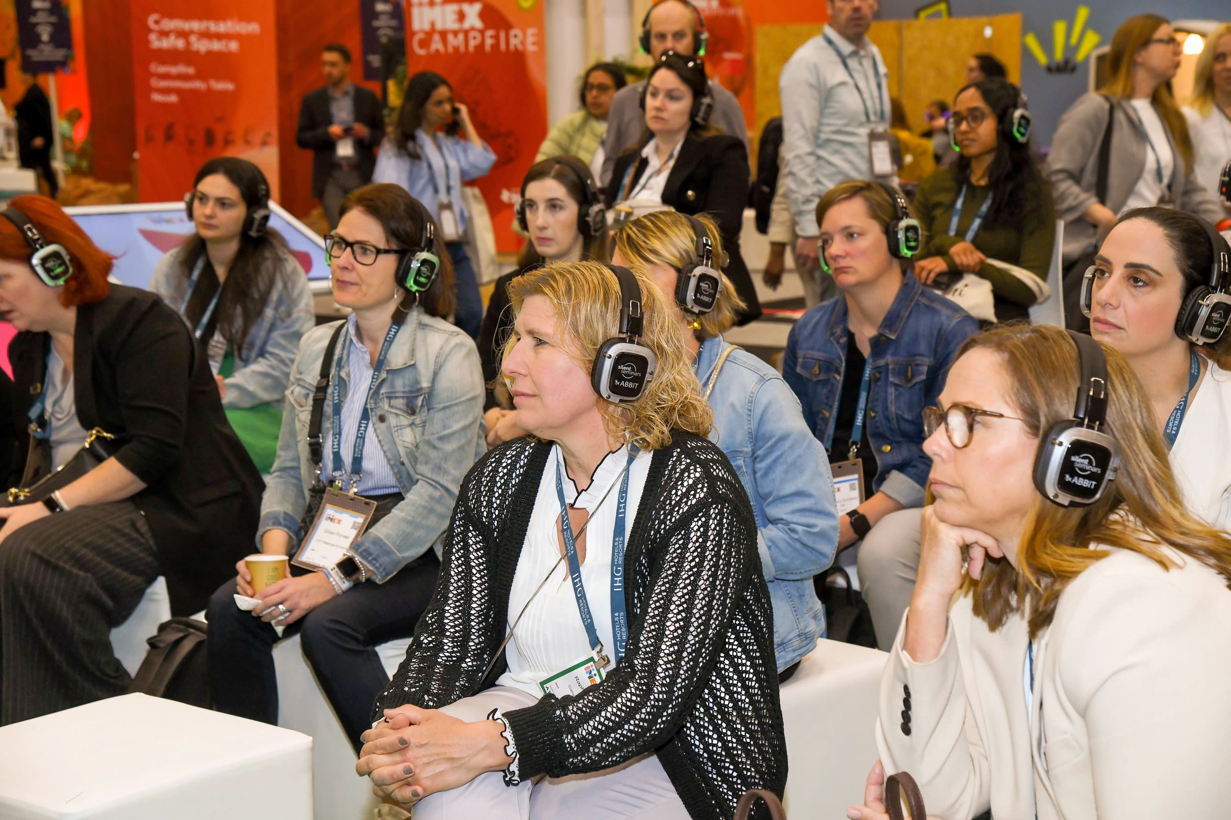 People listening to headphones looking towards the stage