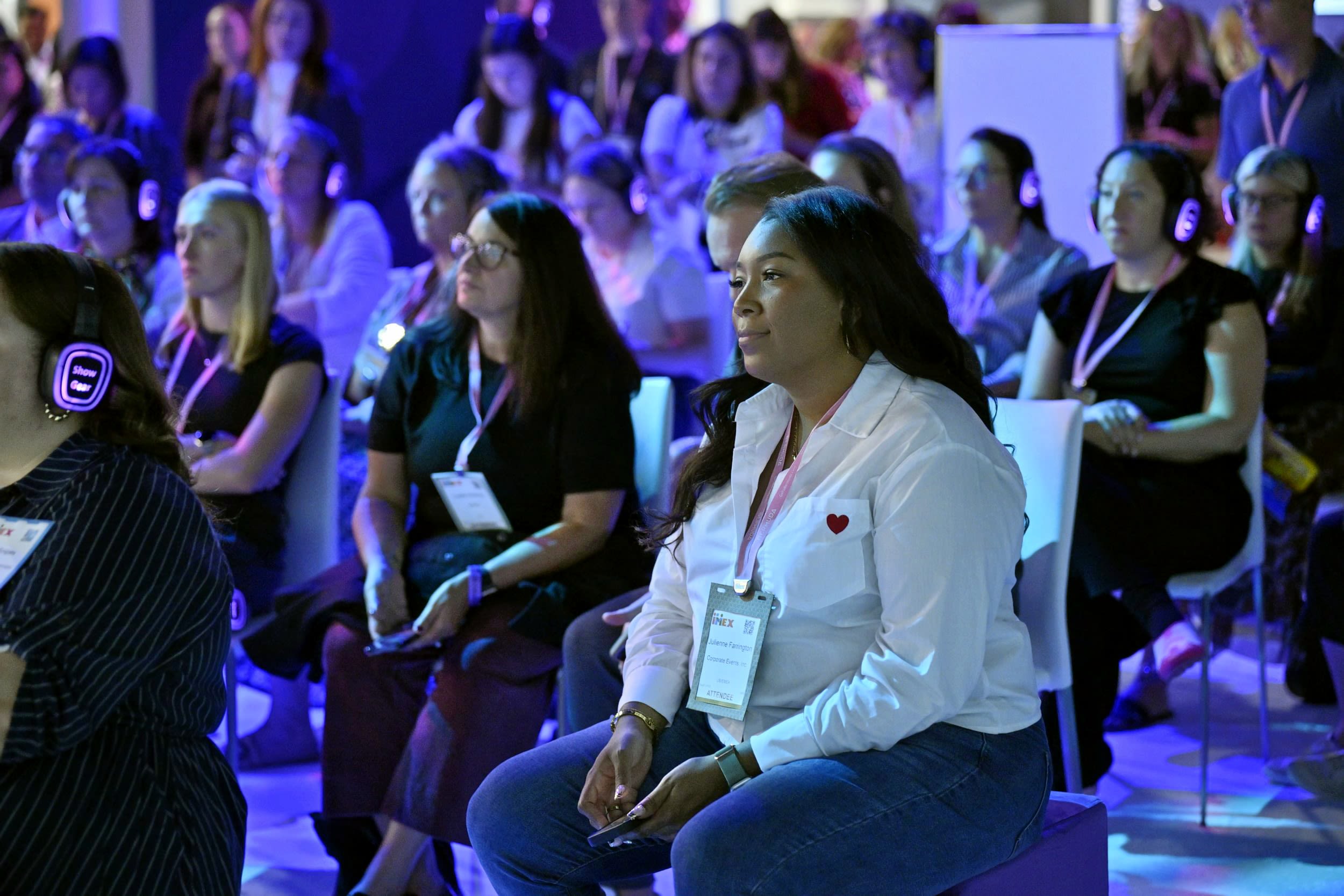 Female listening to an education session watching the speaker with a calm expression.
