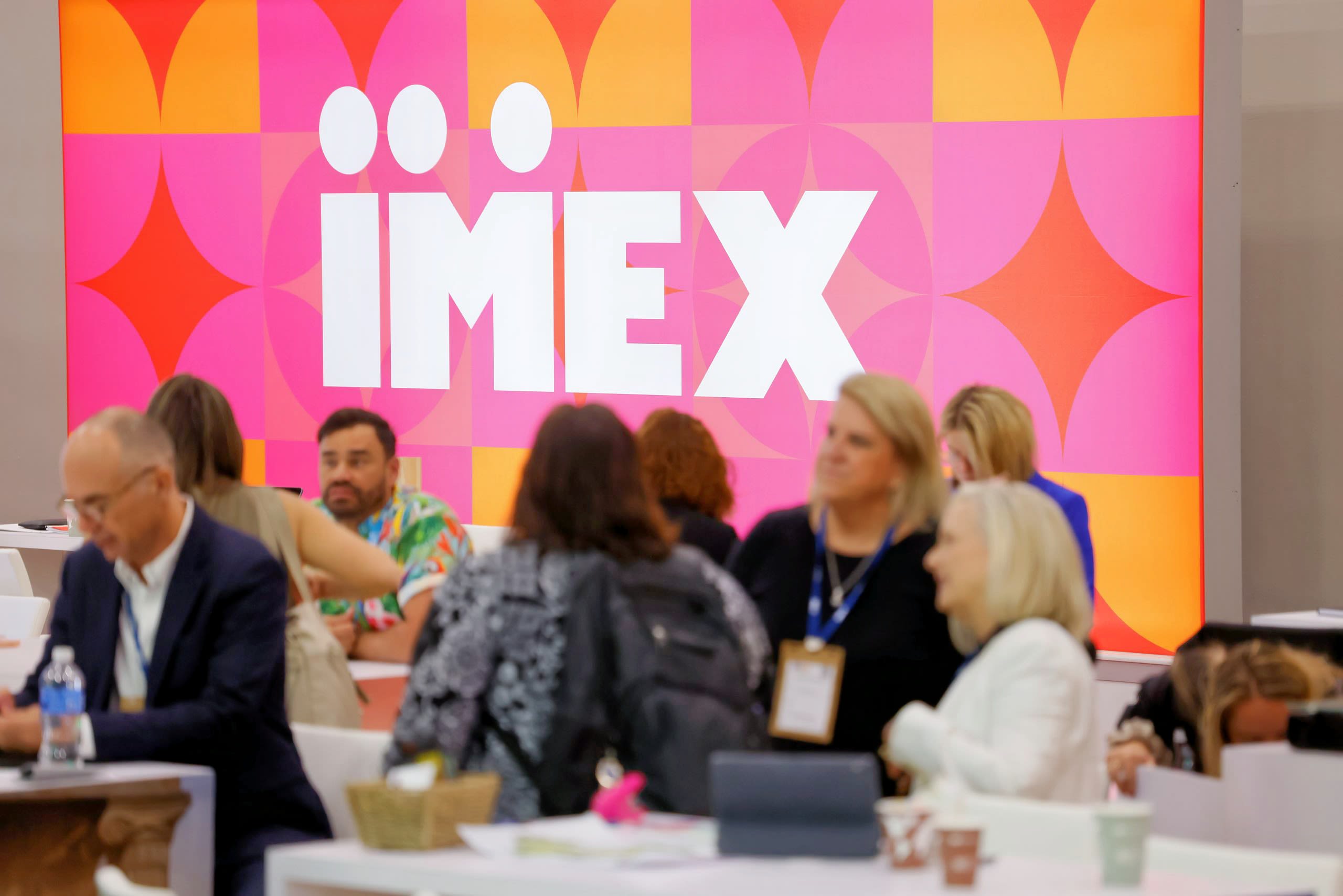 IMEX sign behind people meeting