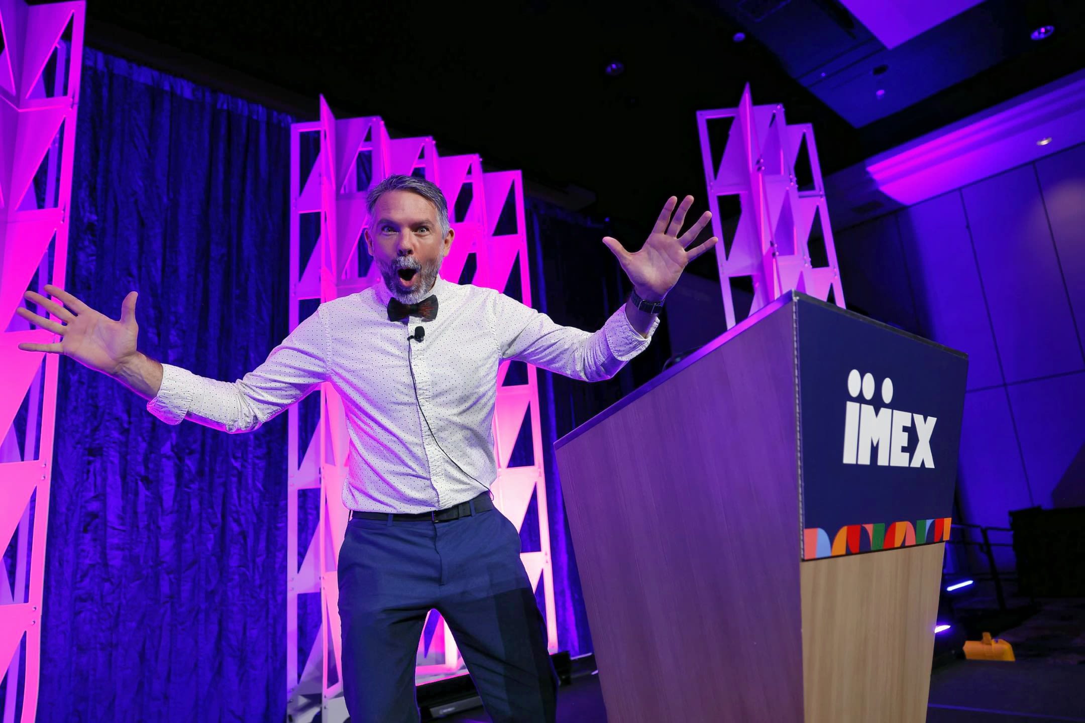 Man spreading arms on stage