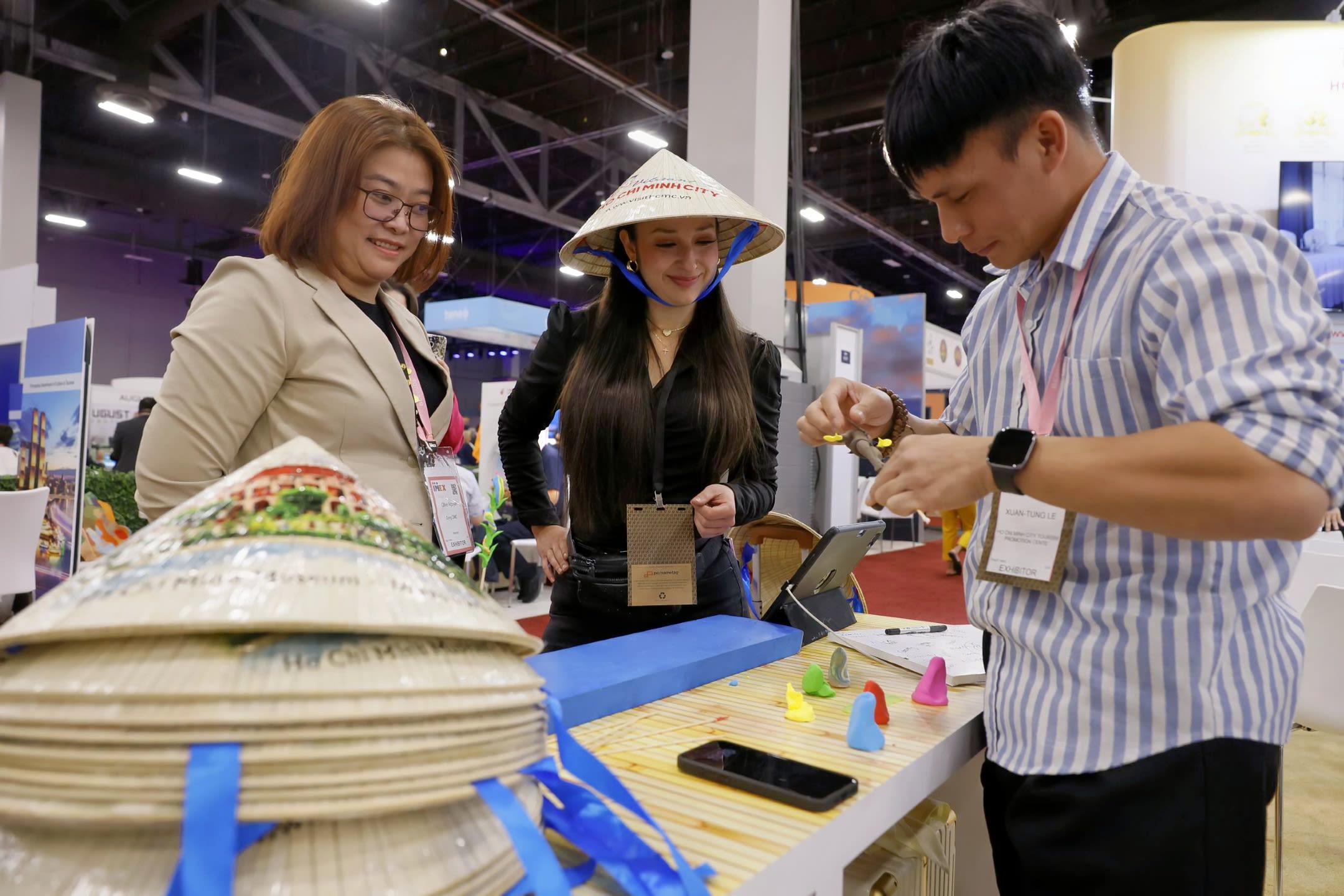Two women watching man make hat
